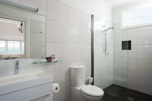 a white bathroom with a toilet and a sink at The Ark Stanley Luxury Bed and Breakfast in Stanley