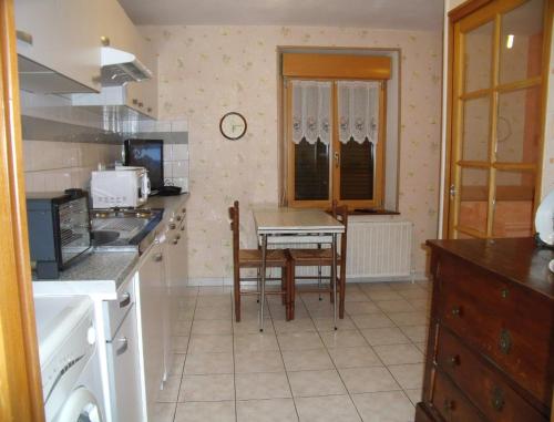 a kitchen with a table and chairs in a room at Gîte Les Hirondelles in Plombières-les-Bains