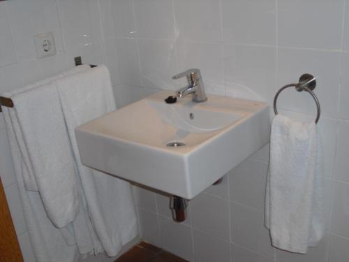 a white sink in a bathroom with towels at Ronda in Ronda