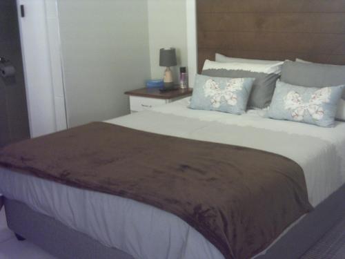 a bedroom with a large bed with blue and white pillows at Tranquility Self Catering in Lüderitz