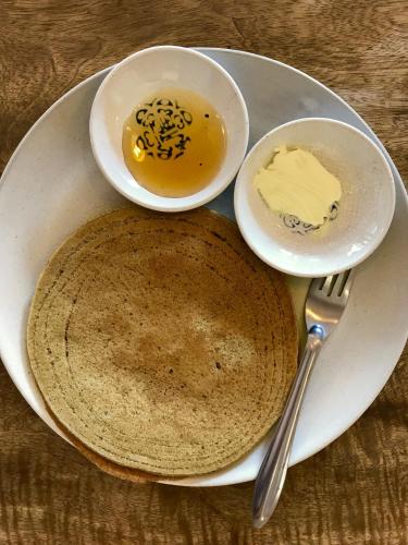 a plate with two bowls of food and butter at Ananda Tree House Eco Homestay in Kathmandu