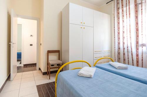een slaapkamer met 2 bedden en een stoel bij Appartamento Tony in Sperlonga