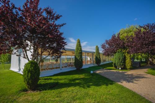 a garden with trees and a building at The Amber Business & Spa Hotel in Oleśnica