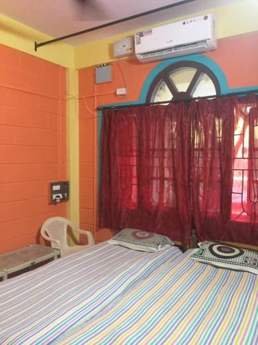 a bedroom with a bed and a window at Nimmu Guest House & Restaurant Gokarna in Gokarna