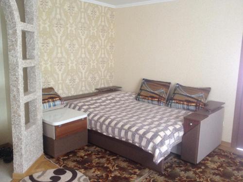 a small bedroom with a bed and a table at Apartment on Ivasyuka 11 in Truskavets
