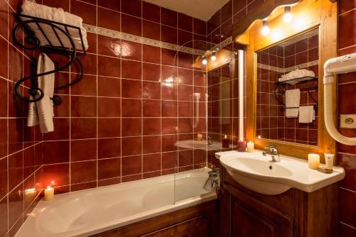 a bathroom with a tub and a sink and candles at travelski home premium - Résidence Chalets Altitude & Ours 5 stars in Arc 2000