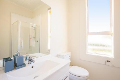 een witte badkamer met een wastafel en een toilet bij Kingston Villa in Kingston
