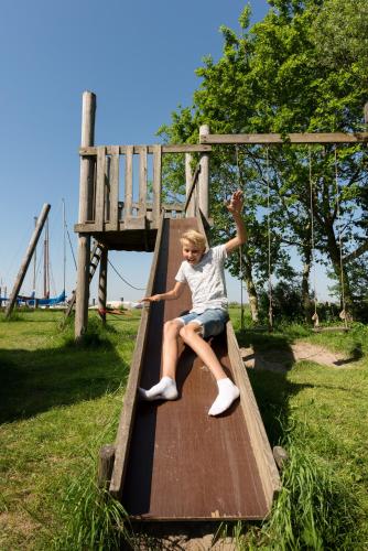 a young girl on a slide at a park at Rufus aan het water in Broek