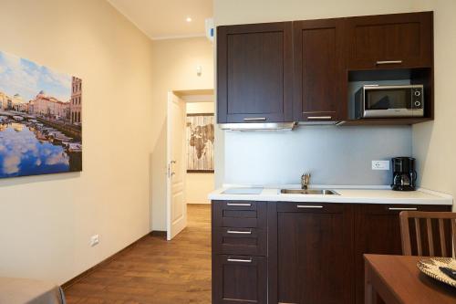 a kitchen with dark brown cabinets and a sink at Miramare Luxury Suites in Trieste