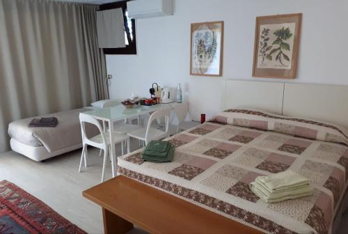 1 dormitorio con 1 cama y 1 mesa con sillas en Bed & Breakfast San Lazzaro Room, en San Lazzaro di Savena