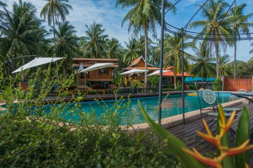 Una piscina de resort con palmeras al fondo en The Ford SunSet Beach Resort, en Wok Tum