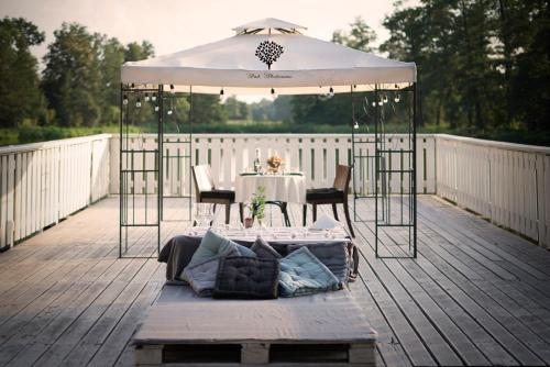 a patio with a table and an umbrella on a deck at Szafirowy Dwór Hotel & Restauracja in Gliwice