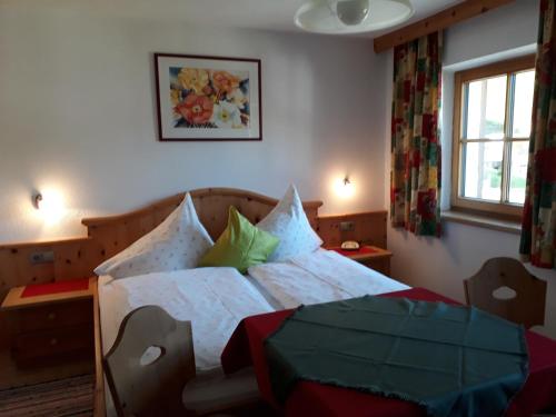 a bedroom with a bed with white sheets and green pillows at Haus Morgensonne in Pettneu am Arlberg