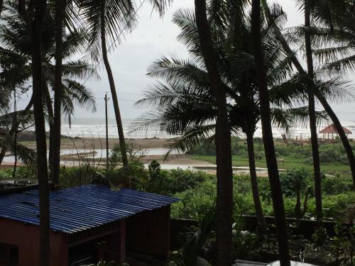 a view of the beach from a resort with palm trees at Nimmu Guest House & Restaurant Gokarna in Gokarna