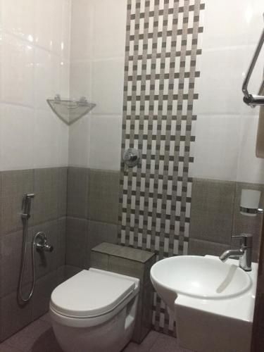 a bathroom with a toilet and a sink at Nimmu Guest House & Restaurant Gokarna in Gokarna