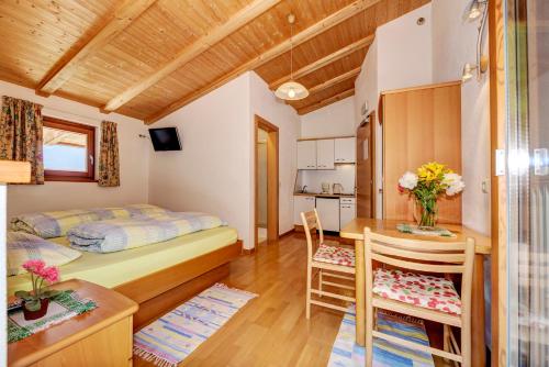a small room with a bed and a table and chairs at B & B Apartments Ortlerblick in Sluderno