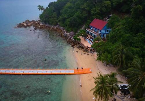 - un bateau orange sur une plage à côté d'une maison dans l'établissement Perhentian Nemo Chalet, aux Îles Perhentian