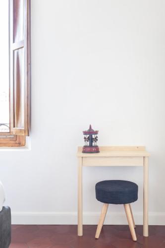 a wooden table with a blue stool next to a desk at Gianburrasca in Florence