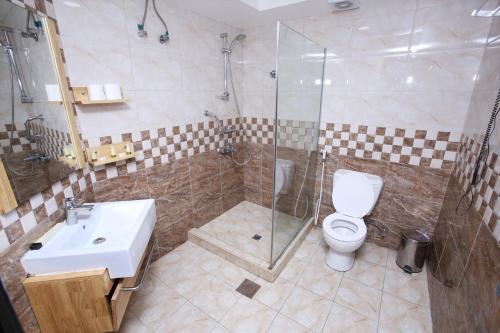 a bathroom with a toilet and a shower and a sink at Zagy Hotel in Dubai