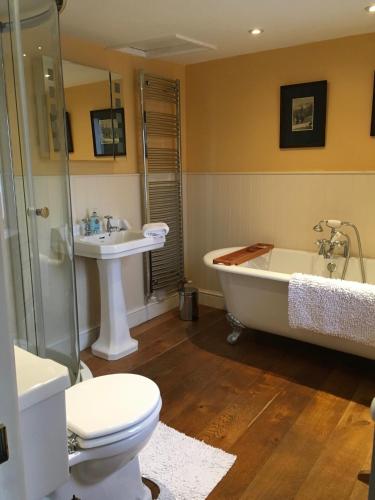 a bathroom with a tub and a toilet and a sink at Woodbine Cottage in Tenby