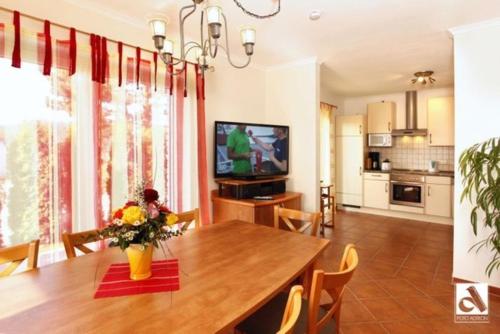 a kitchen and dining room with a table and a television at Haus Seeschwalbe in Ostseebad Karlshagen