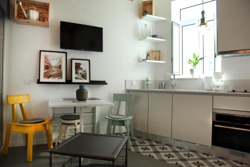uma cozinha com um balcão, uma mesa e cadeiras em Dubocage45Citycenter em Faro