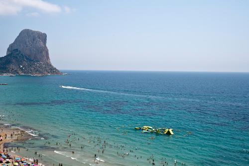 
a beach scene with surfers and boats at Hotel Bahía Calpe by Pierre & Vacances in Calpe
