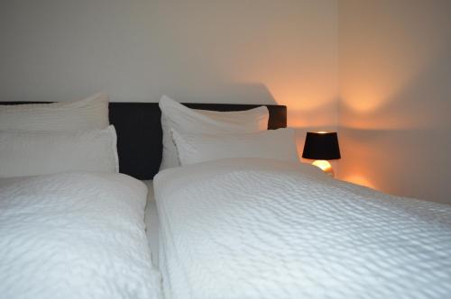 Stadt Apartment Nr. 1 Bad Wilsnack في باد فيلسناك: كان هناك سريرين بيض يجلسون بجانب بعضهم البعض في غرفة النوم