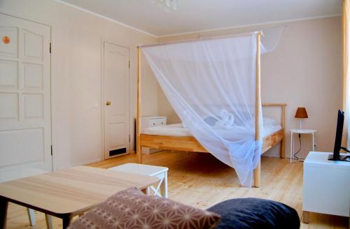 a bedroom with a bed with a mosquito net at Guest House Vasara in Nida