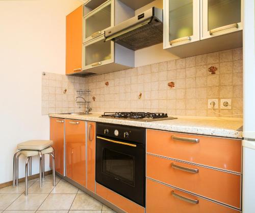 モスクワにある2-room apartment at Smolenskaya metroのキッチン(オレンジ色のキャビネット、コンロ付)