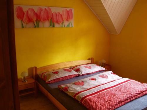 a bedroom with a bed with a painting of red tulips at Penzion Dominika in Oravský Biely Potok