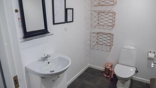 a white bathroom with a sink and a toilet at Adventure Park Apartments in Ringkøbing