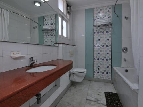 a bathroom with a sink and a toilet and a shower at Mehra Residency at The Airport in New Delhi