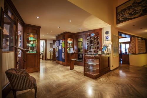 una sala de estar con suelo de madera y una habitación con una silla en Hotel Titano, en San Marino