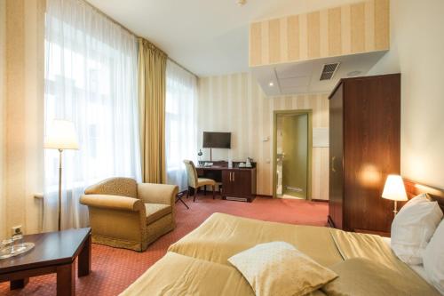 a hotel room with a bed and a chair at Monika Centrum Hotels in Rīga