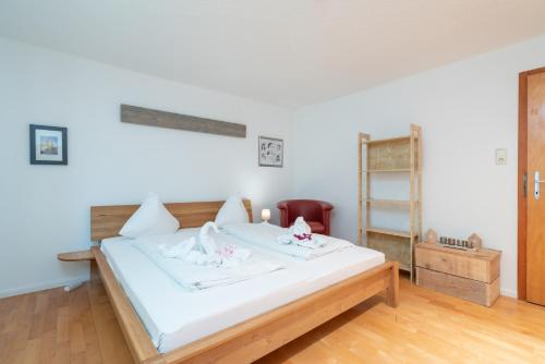 a bedroom with a white bed with pink flowers on it at Apartments Garden House in Niedernsill