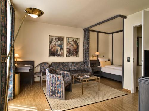 a living room with a couch and a bed at Posthaus Hotel Residenz in Kronberg im Taunus
