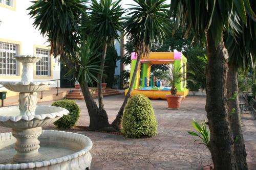 a fountain in a courtyard with a playground at Hotel Lozano in Antequera