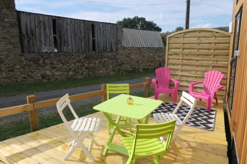 a group of chairs and a table on a deck at Tiny House à 30 min du Puy du Fou jusqu'à 6 personnes in Yzernay
