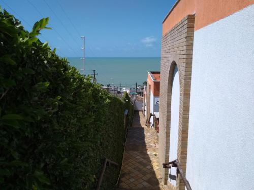 an alley between a building and a hedge at Apartamentos Ponta do Sol in Natal