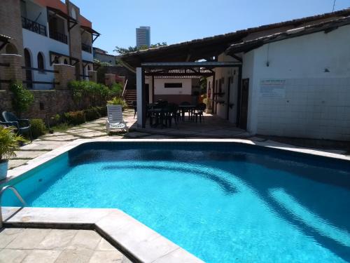 a swimming pool in the backyard of a house at Apartamentos Ponta do Sol in Natal