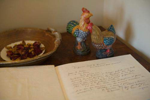 an open book on a table with chickens and a bowl of food at ty dreux entre terre et mer in Saint-Thégonnec