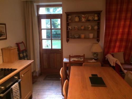 a kitchen with a wooden table and a window at Newhall in Glasgow
