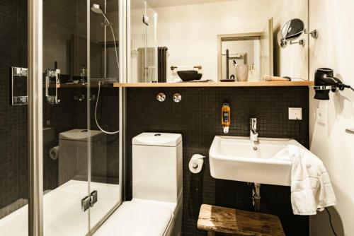 a bathroom with a sink and a shower at Bold Hotel München Zentrum in Munich