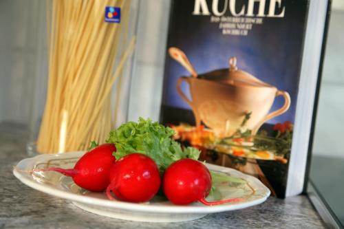 a plate of tomatoes on a table next to a book at Hotel-Garni Jakober - B&B und Appartements in Tux