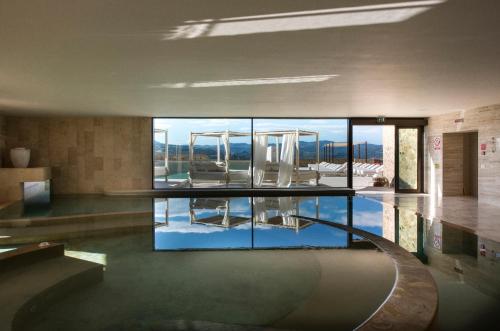 a room with a pool of water in a house at Castello di Velona Resort, Thermal SPA & Winery in Montalcino