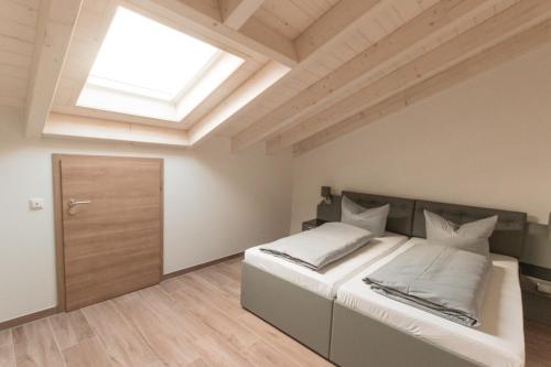 a bedroom with a large bed and a skylight at Stadthotel Donauwörth in Donauwörth
