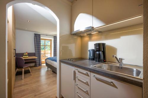 una cucina con un lavandino e un letto in una stanza di Beim Rohrer a Kirchberg in Tirol