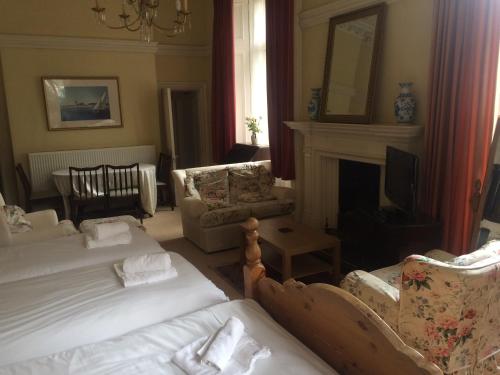 a living room with two beds and a fireplace at Newhall in Glasgow