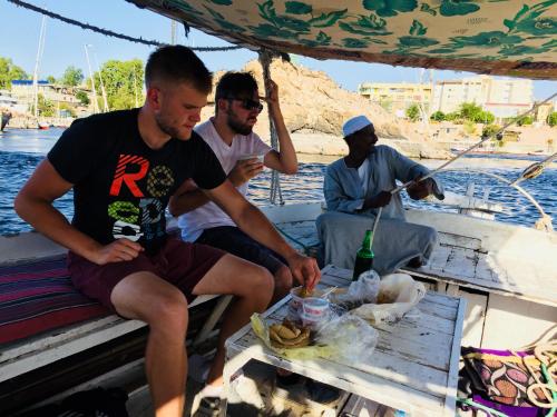 a group of men sitting on a boat at david hostel in Aswan